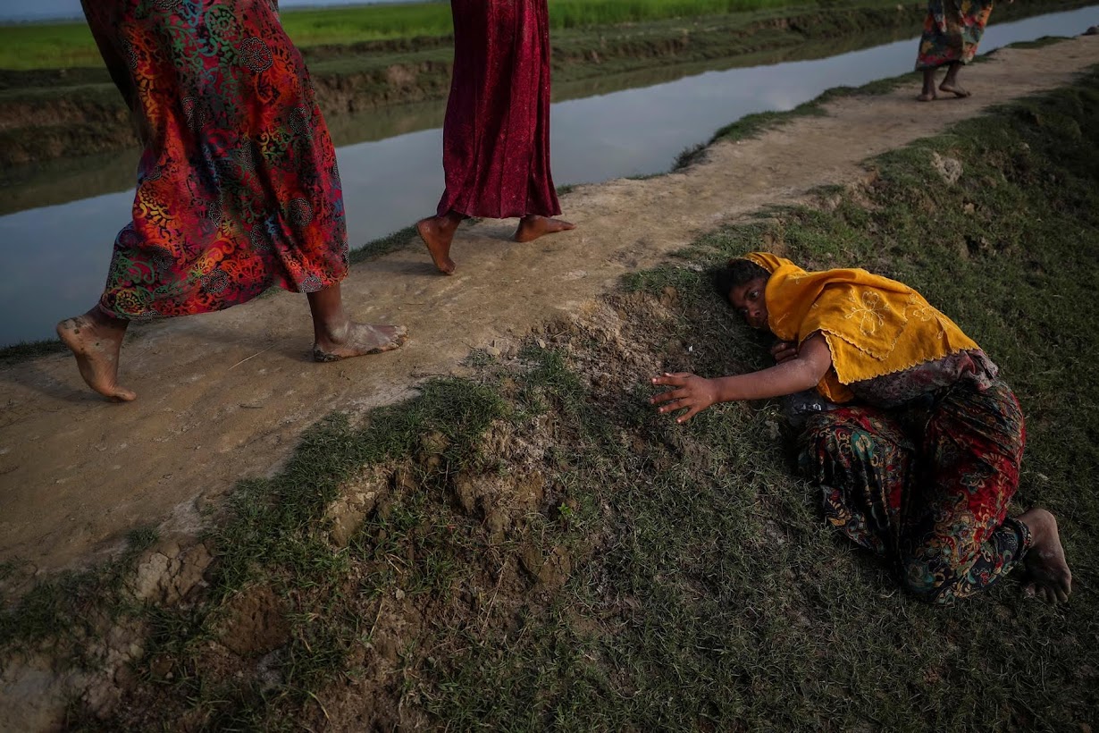 An exhausted Rohingya refugee fleeing violence in Myanmar cries for help from others crossing into Palang Khali.